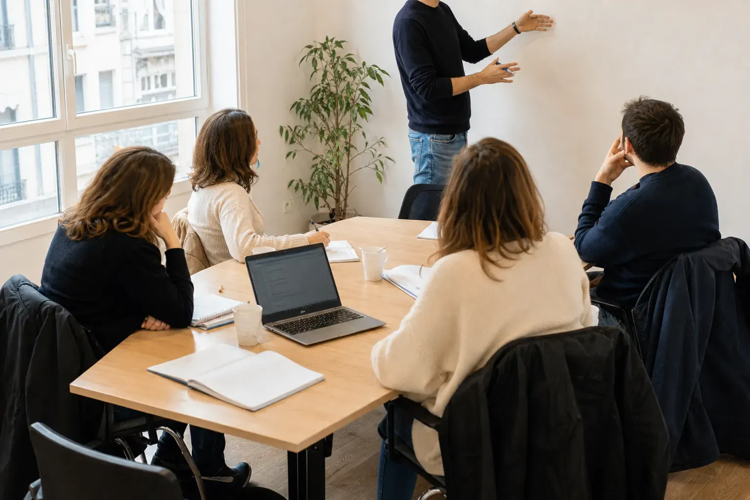 Adultes réunis autour d’une table pendant un cours d’anglais à Lyon, lumière du jour